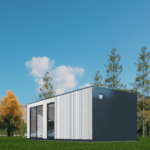 Maison modulaire moderne avec murs extérieurs blancs et bleu foncé, grandes fenêtres en verre, située dans une zone herbeuse avec des arbres élancés, ciel clair avec quelques nuages, montagnes en arrière-plan.