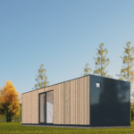 Maison modulaire moderne avec façade divisée en panneaux de bois clairs et matériaux sombres, grande porte vitrée, petite fenêtre carrée, située dans une zone herbeuse avec des arbres et des montagnes en arrière-plan, ciel bleu dégagé.