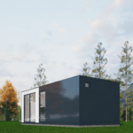Maison modulaire moderne avec façade sombre, grandes fenêtres en verre, située dans une zone herbeuse avec des arbres élancés et des montagnes en arrière-plan, ciel partiellement nuageux.