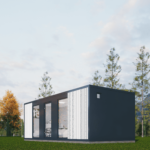 Bureau modulaire moderne avec panneaux sombres et clairs, grandes fenêtres et portes vitrées, intérieur visible avec espace de travail, situé dans une zone herbeuse avec des arbres élancés et des montagnes, sous un ciel partiellement nuageux.