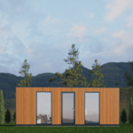 Petit bâtiment rectangulaire moderne en bois avec de grandes fenêtres ou portes vitrées, situé dans une zone herbeuse avec des arbres et des montagnes en arrière-plan sous un ciel partiellement nuageux.