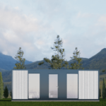 Bureau modulaire moderne avec panneaux sombres et clairs, grandes fenêtres et portes vitrées, intérieur visible avec espace de travail, situé dans une zone herbeuse avec des arbres élancés et des montagnes, sous un ciel partiellement nuageux.