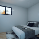 Chambre modulaire moderne avec lit double, couverture à motifs, coussins sombres, grandes fenêtres en verre, table de chevet avec lampe et photo encadrée, murs clairs, sol en bois clair ou stratifié.